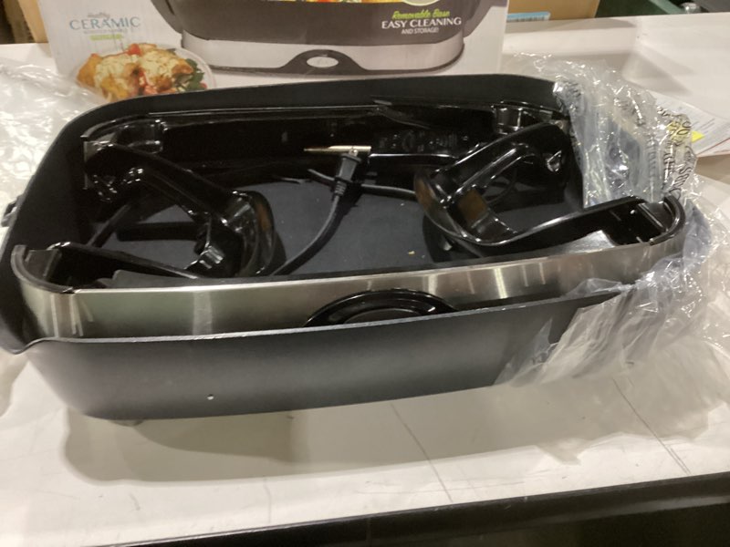 Condition photo showing As Is for not tested crack in base presto 06857 16-inch electric foldaway skillet, black