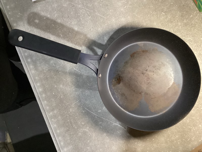 Condition photo showing As Is for oxo obsidian pre-seasoned carbon steel, 10" frying pan skillet with removable silicone handle holder, induction, oven safe, black