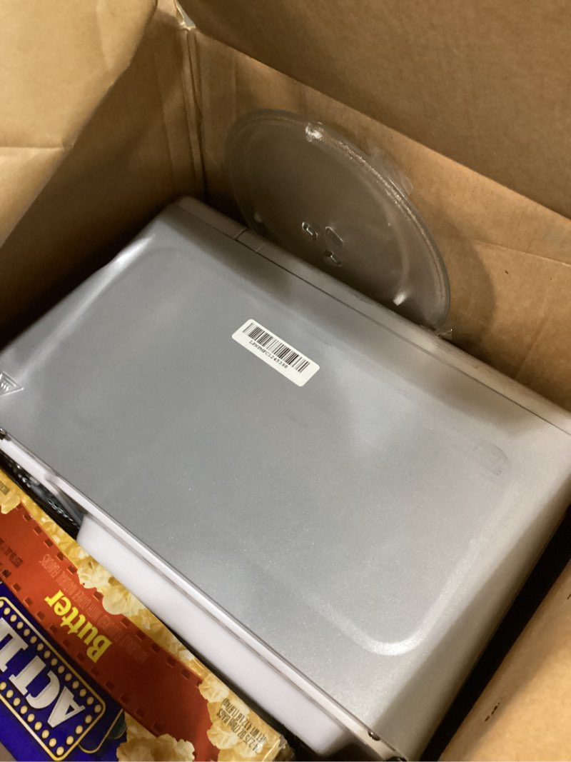 Condition photo showing As Is for emerson mw7601sl countertop microwave oven with sleek mirrored finish glass door, 700w, 10 power levels and 6 pre-programmed settings with child safe lock, 0.7. cu. ft., silver 0.7 cu. ft.