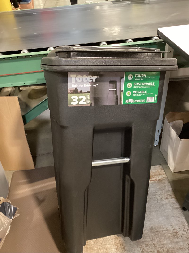 Condition photo showing As Is for toter 32 gallon black rolling outdoor garbage/trash can with wheels and attached lid