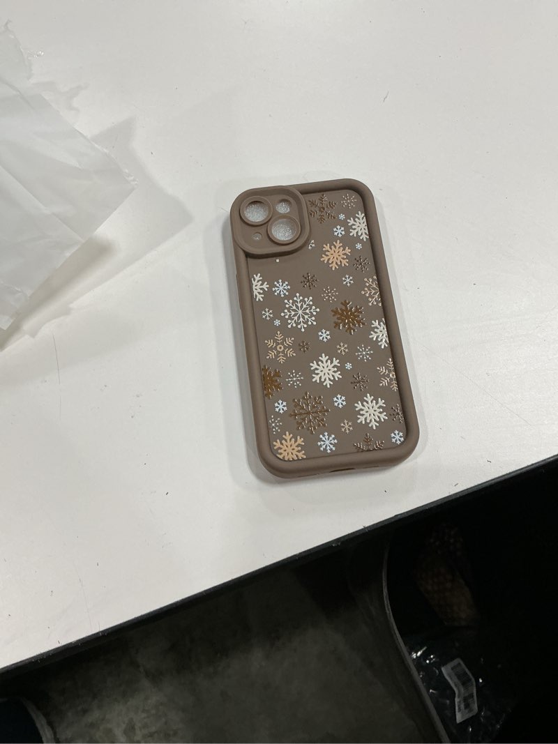 Condition photo showing Good Condition for brown silicone phone case featuring a white, tan, and gold snowflake pattern, designed for an iPhone 14