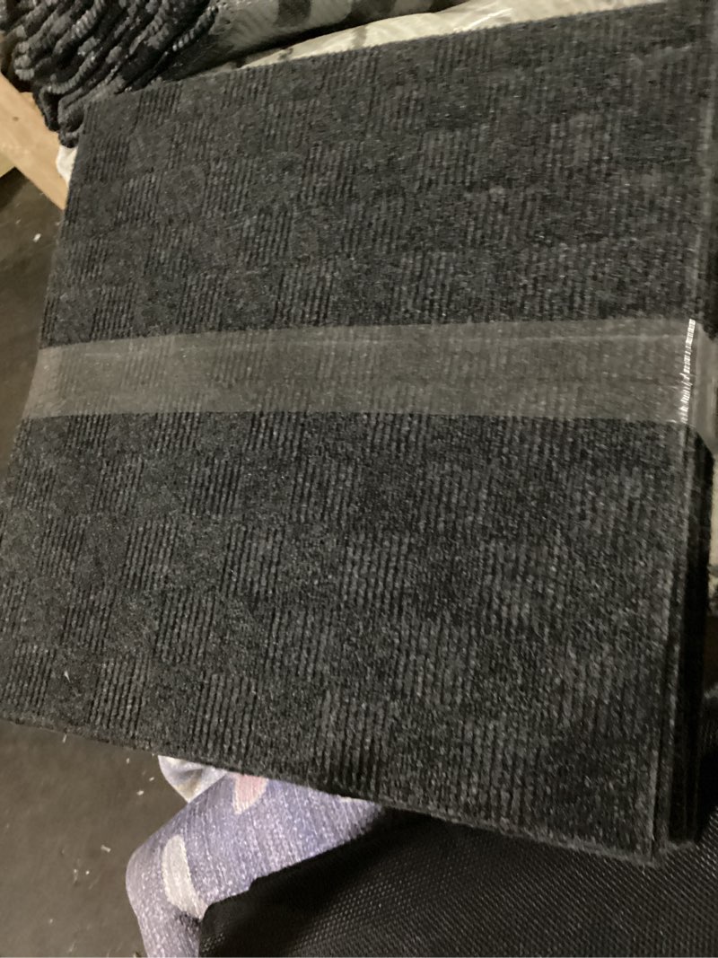 Condition photo showing As Is for mohawk home 24" x 24" indoor/outdoor 0.25" pile height, peel and stick carpet tile, black polyester, (15 tiles) (60 sqft/box)