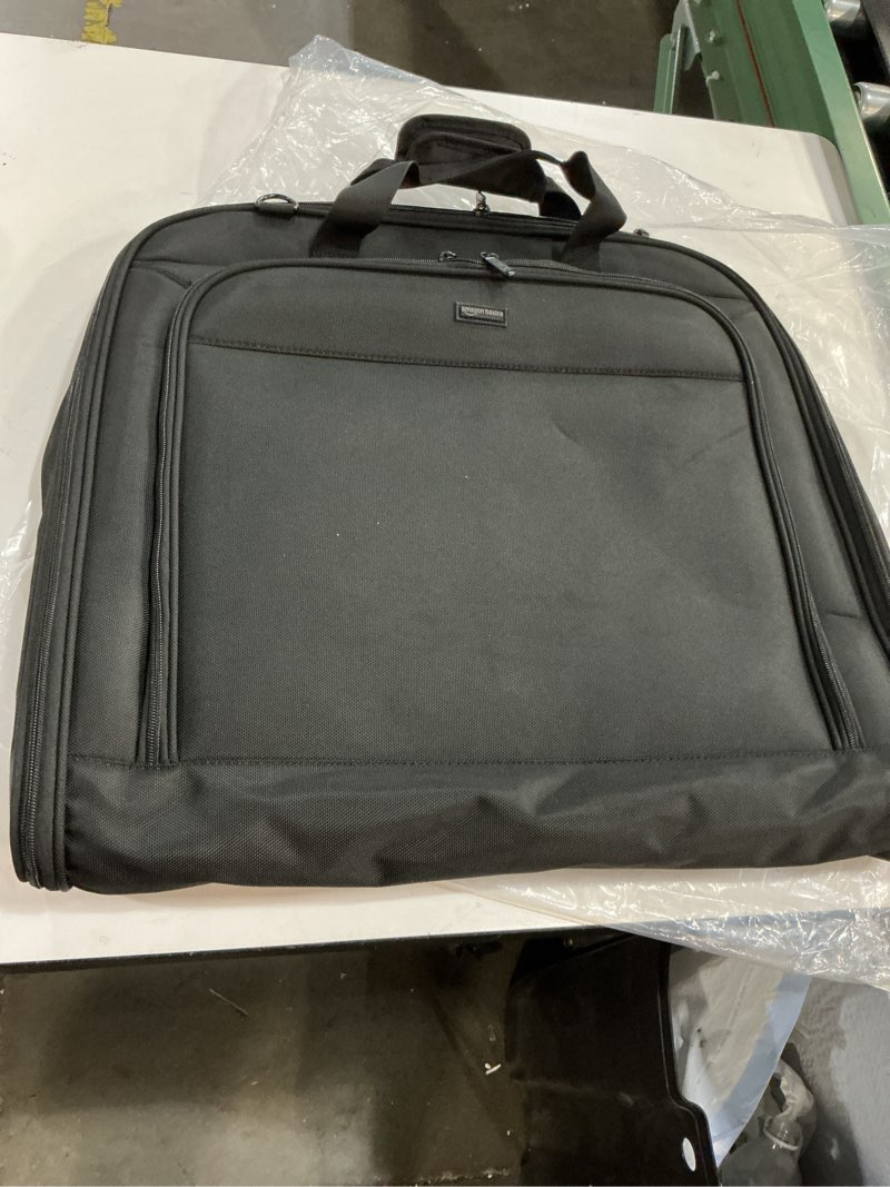 Condition photo showing New/Like New for Amazon Basics Premium Garment Bag designed for travel and keeping clothes wrinkle-free. It is constructed from durable 1680D polyester and typically features exterior and interior pockets for accessories