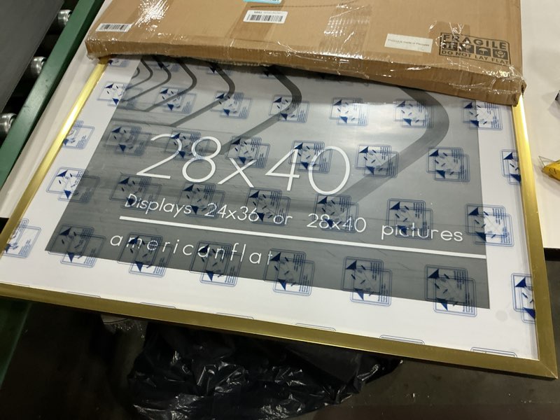 Condition photo showing As Is for Americanflat 28x40 Poster Frame with Polished Plexiglass - Use as 24x36 Frame with Mat or Display 28x40 Photo Without Mat - Streamline Collection - Thin Border Picture Frames for Wall - Gold Gold 28x40 1 Pack