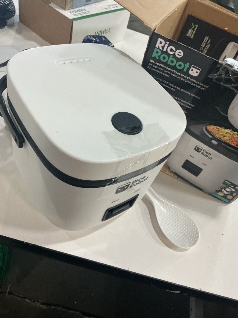 Condition photo showing Good Condition for rice robot personal rice cooker, pfas-free, nonstick. 1 quart capacity, with stainless steel steamer tray, measuring cups, recipe book with 60 recipes, and serving spoon, as seen on tv 2-cup (uncooked) | 4-cup cooked