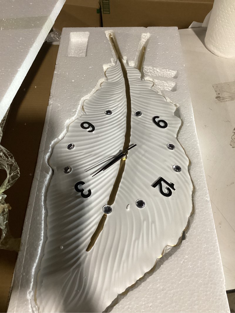 Condition photo showing Good Condition for 18x27 inch large modern feather leaf shape wall clock for living room decor, white unique silent decorative art clock for home bedroom office dining kitchen