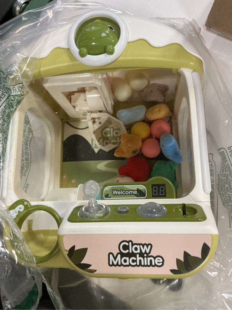 Condition photo showing As Is for cossy claw machine for kids,large dinosaur toy claw machine,mini arcade claw machine with sound lights,360° crystal joystick,fidget toys and surprise eggs,birthday gifts for girls boy
