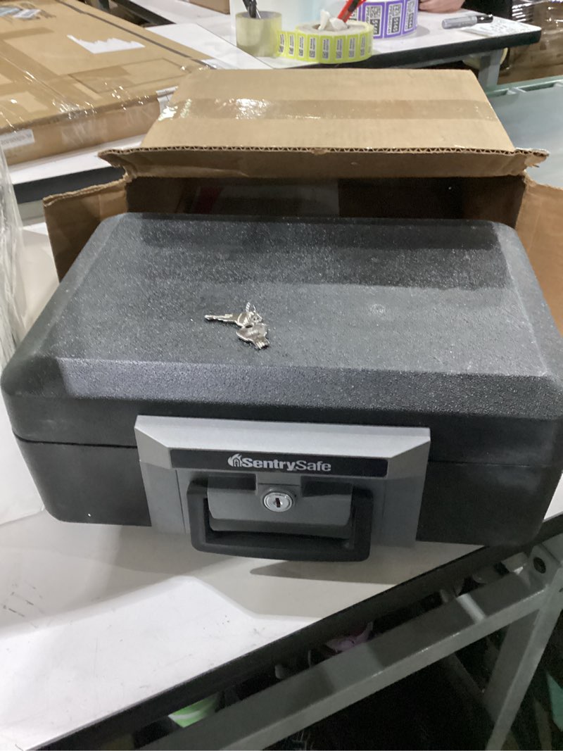 Condition photo showing As Is for sentrysafe fireproof safe box with key lock, chest safe with carrying handle to secure money, jewelry, documents, 0.25 cubic feet, 6.3 x 15.3 x 12.1 inches, 1160