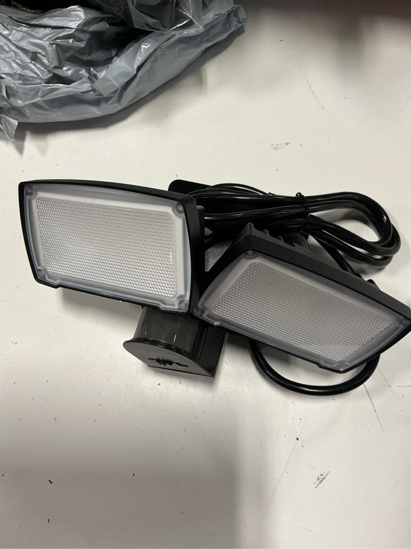 Condition photo showing As Is for lutec 21w plug in motion sensor light outdoor, flood lights outdoor motion sensor,2500lm, 5000k daylight,ip65 waterproof,adjustable 2 heads wall light for garage, porch, yard - black black 1 pack