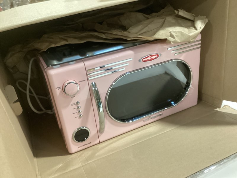 Condition photo showing As Is for Nostalgia Retro Countertop Microwave Oven - 1.1 Cu Ft & 1000 Watt Power- Easy to Clean with Removable Glass Turntable - Child Safety Lock - 12 Programs - Digital Clock - Pink Retro Classic 1.1 Cu. Ft. Pink
