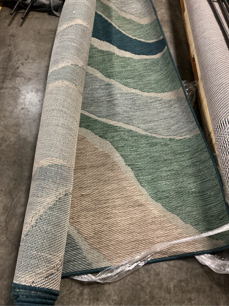 Condition photo showing As Is for stainmaster aqua wave 8 x 10 (ft) loomed polypropylene blue rectangular outdoo