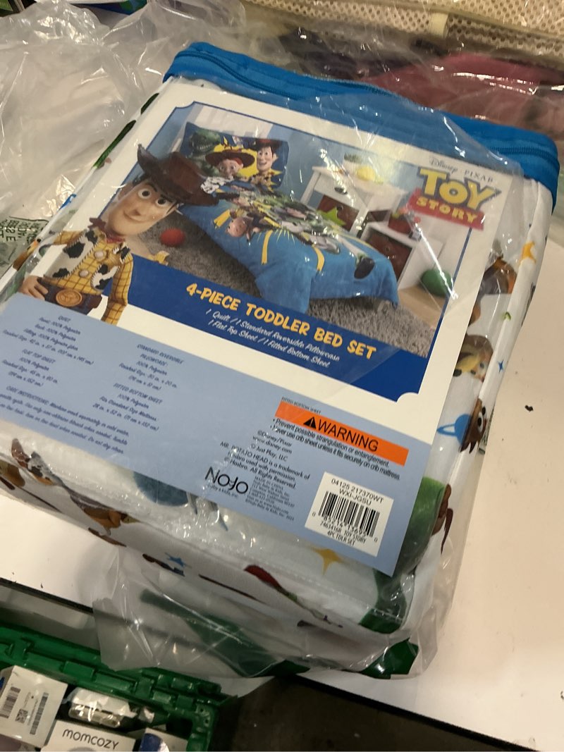 Condition photo showing New/Like New for nojo disney toy story taking action blue, green and yellow 4 piece toddler bed set - comforter, fitted bottom sheet, flat top sheet, and reversible pillowcase