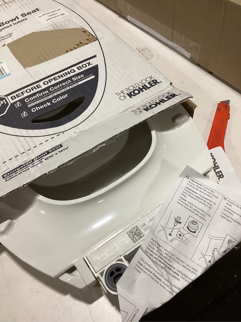 Condition photo showing As Is for kohler 20110-96 brevia, slow close toilet seat, elongated toilet seat, grip-tight bumpers quick-attach hardware, biscuit biscuit elongated quiet-close