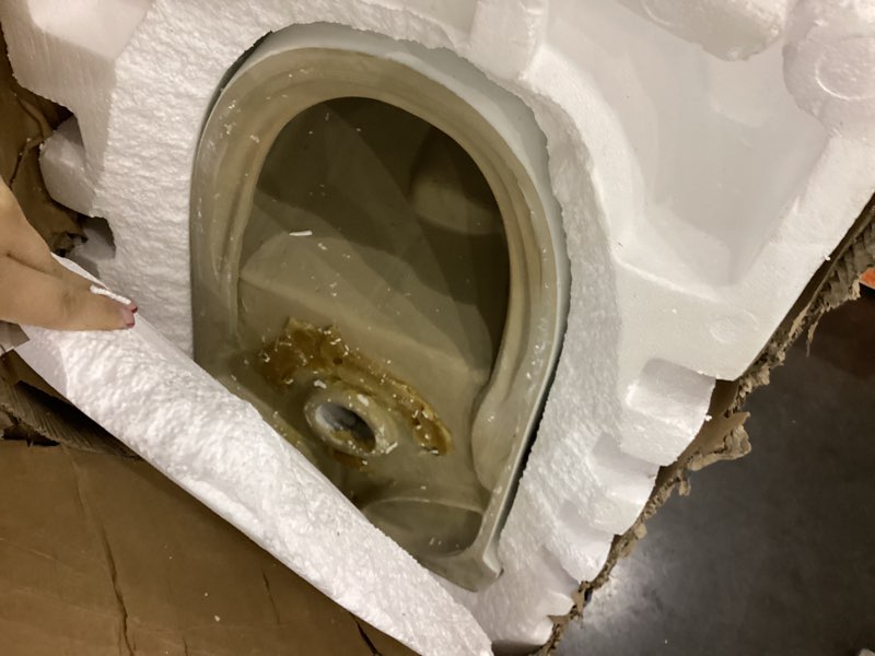 Condition photo showing As Is for One-Piece Elongated Toilet Left Side Flush in whitw, 10\" Rough-In