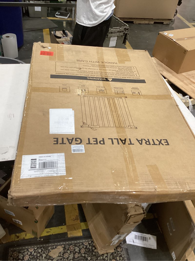 The image shows a packaged Extra Tall Pet Gate, designed to keep pets contained within safe areas of the home.