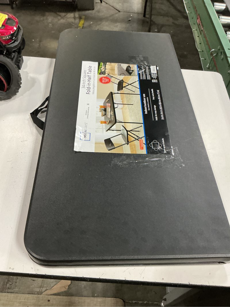 Condition photo showing As Is for mainstays 34" square resin fold-in-half table, rich black