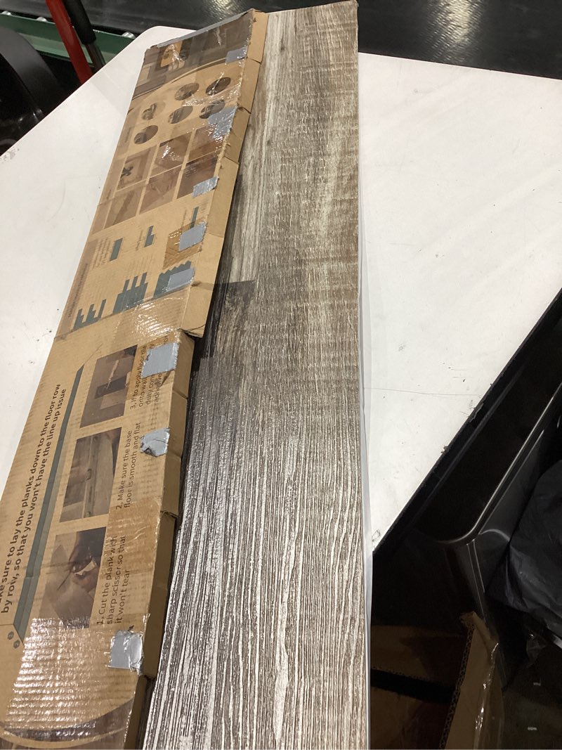 Condition photo showing Good Condition for art3d 12-pack 18 sq.ft peel and stick floor tiles vinyl plank flooring wood look, adhesive and waterproof tile sticker for bedroom, living room, kitchen, rv in black 36 x 6 x 0.1 inches black 12