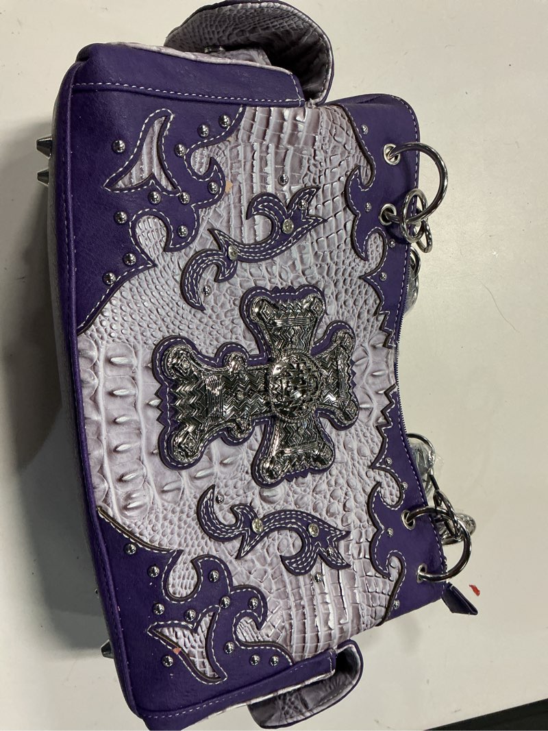Condition photo showing New/Like New for bolso con alas bordadas en morado y tonos naturales y cruz grande