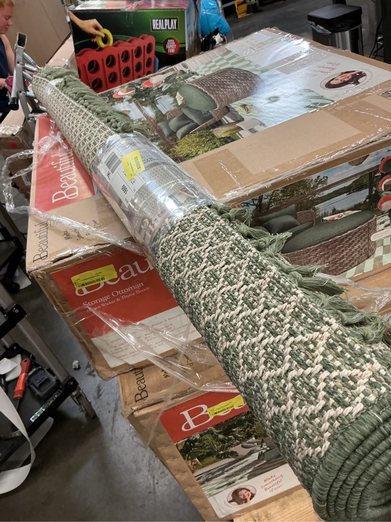 Condition photo showing As Is for better homes & gardens 5’x7’ green tassel outdoor rug
