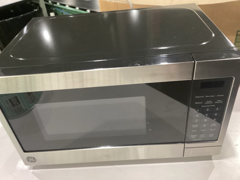 Condition photo showing As Is for ge compact countertop microwave oven, 0.7 cubic ft., 700-watt capacity, 6 auto cooking settings, child-lock technology, dorm room or apartment, stainless steel 0.7 cu.ft. stainless steel