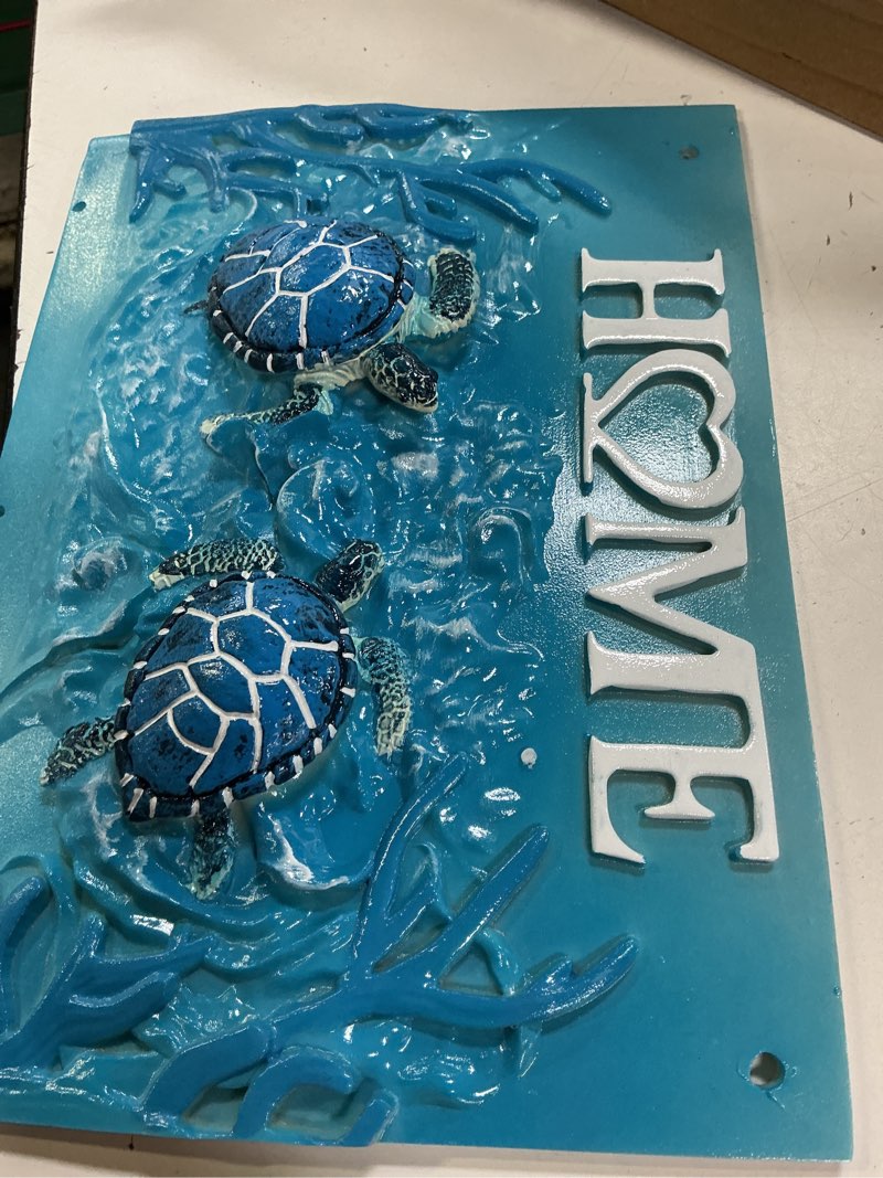 Condition photo showing Good Condition for coastal-themed "home" wall plaque adorned with two detailed 3d blue sea turtles swimming amidst textured ocean waves and coral