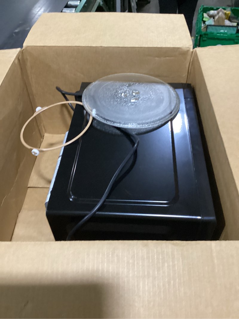 Condition photo showing As Is for Farberware 0.7 Cu. Ft. Countertop Microwave Oven – 700 Watts Power, Auto Cook Settings, Defrost, Easy Clean and Child Safety Lock - Black 0.7 Cu. Ft Black