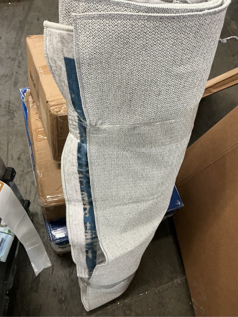 Condition photo showing As Is for 4 ft grey area rug machine washable