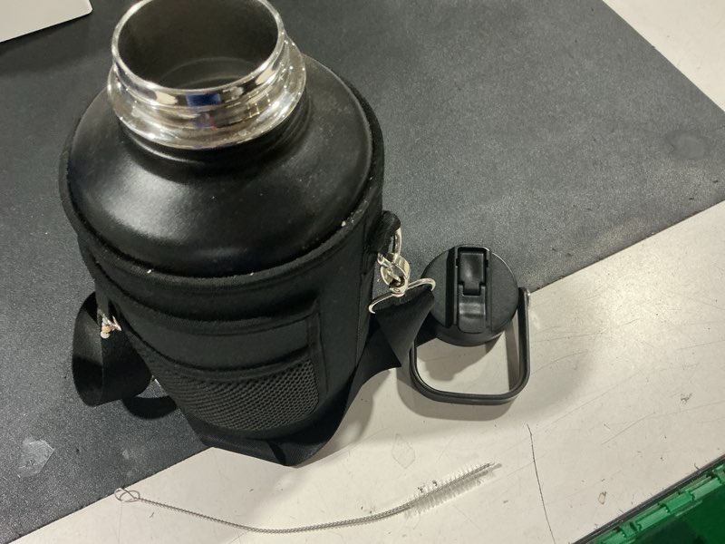 Condition photo showing As Is for (missing straw & extra lid) 64 oz insulated water bottle with carrier bag, indigo black | stainless steel, vacuum insulated keep cold 48 hrs, half gallon large water jug, for travel, sport, gym, hiking indigo/black 64 ounces