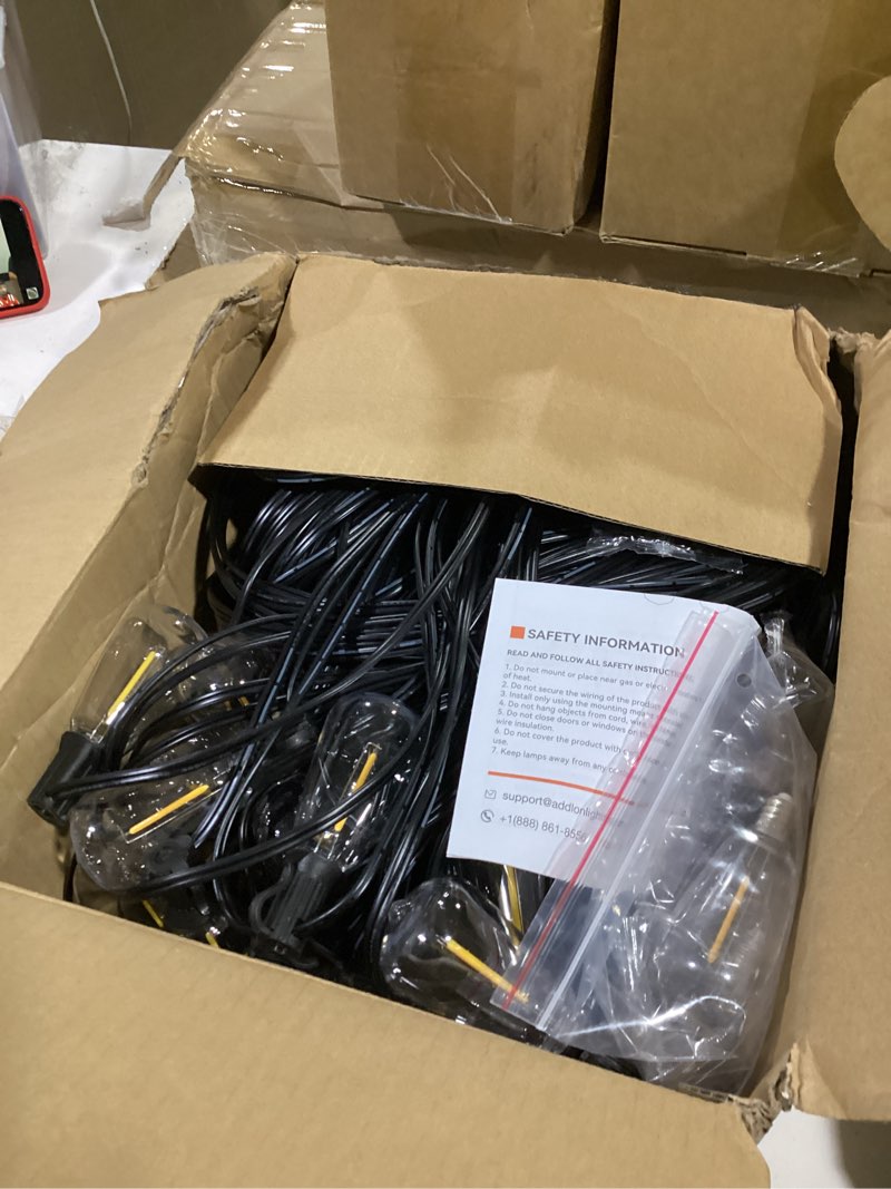 Condition photo showing As Is for addlon 200ft(50ft*4) led outdoor lights waterproof patio lights with 64 shatterproof st38 replaceable bulbs(4 spare), dimmable outside hanging light connectable for porch, backyard 200ft(60 sockets)