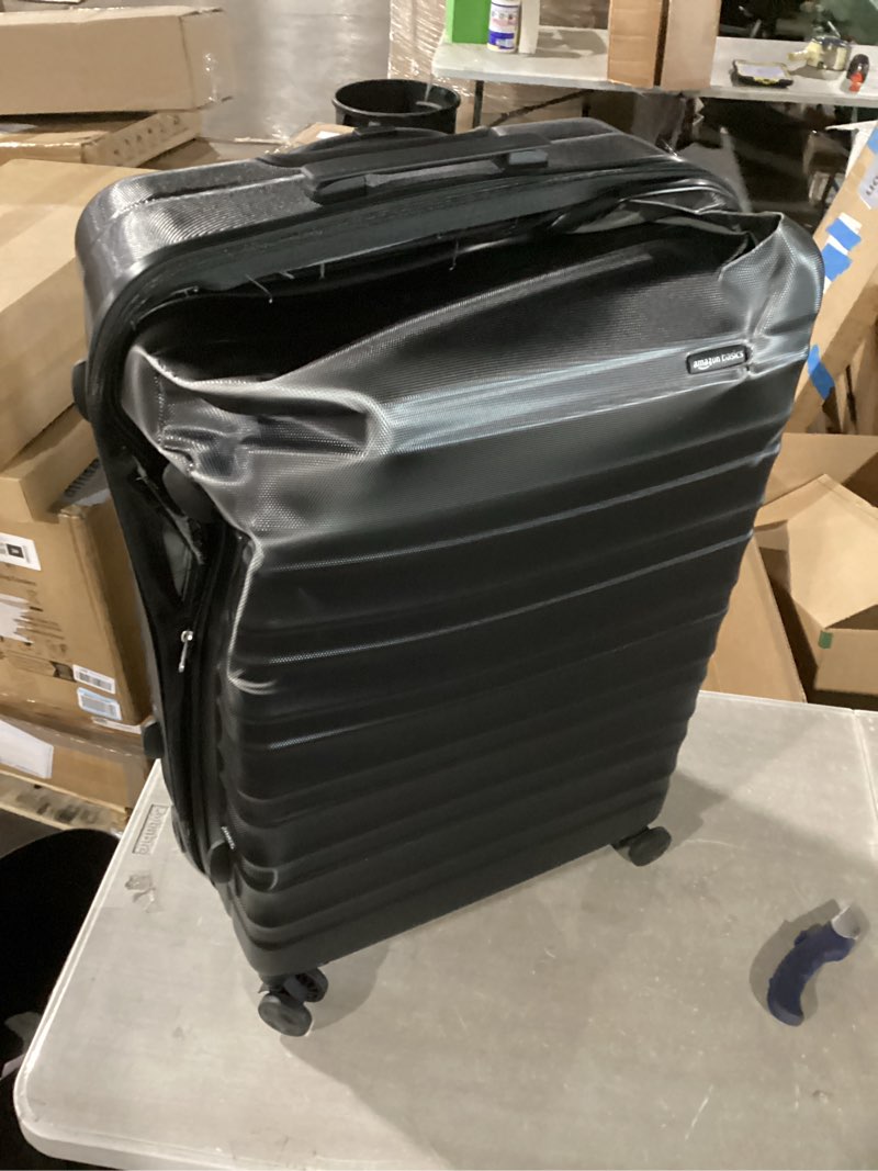Condition photo showing As Is for amazon basics 30" hardside large checked luggage, hardshell suitcase with wheels, expandable for up to 15% more space, with scratch-resistant surface, four multi-directional wheels, black black large checked