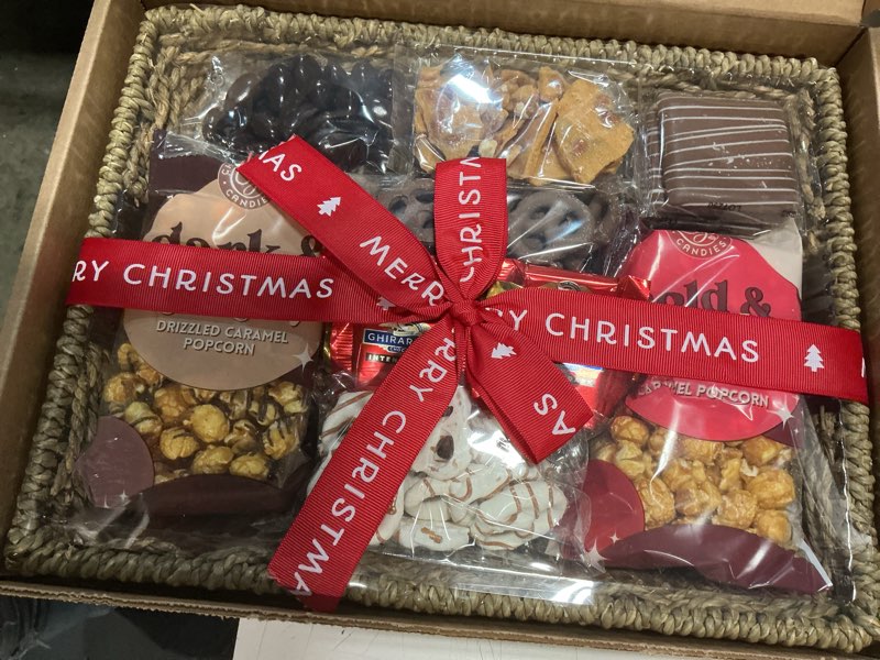 Condition photo showing New/Like New for (best if used by 08/25/2026)a gift inside merry christmas chocolate caramel and crunch grand gift basket