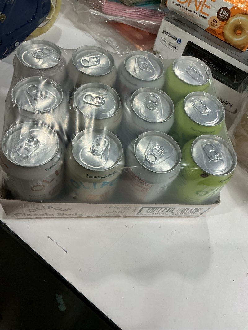Condition photo showing New/Like New for BB: mar 17/27 OLIPOP Prebiotic Soda Pop, Classic Soda Variety, Pantry Pack Packed with Prebiotics, Fiber, and Botanicals, Gluten Free, Vegan, GMO Free, 12oz (12-Cans)