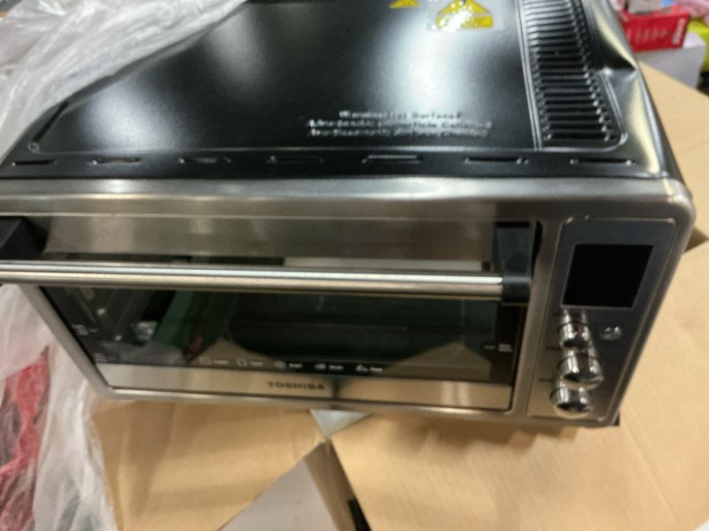 Condition photo showing As Is for toshiba 10-in-1 convection toaster oven, 6-slice countertop oven, 1500w with toast, bake, broil, rotisserie & pizza functions, lcd knob controls, 6 accessories, stainless steel 25l convec. ss