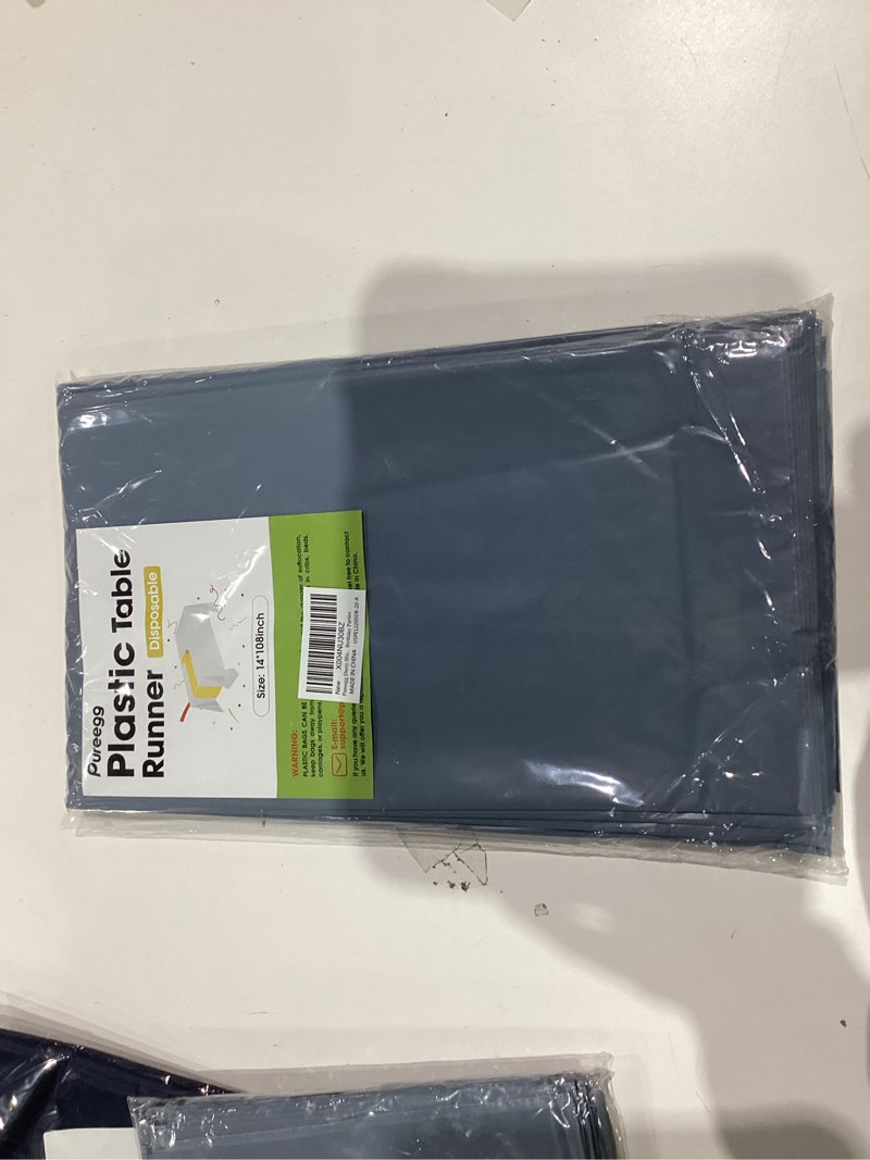 Condition photo showing New/Like New for Pureegg Dusty Blue Plastic Table Runners - 20 Pack, 14'' x 108'', Water Resistant & Disposable Centerpiece Decorations for Table Cloth, Wedding, Birthday, Holiday, Baby Shower, Party, Home Decor Dusty Blue 20 Pack – 14" x 108"