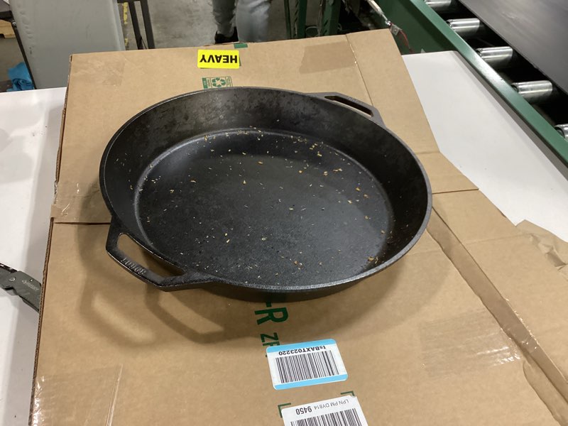 Condition photo showing As Is for Lodge 17 Inch Pre-Seasoned Cast Iron Skillet - Dual Assist Handles - Use in the Oven, on the Stove, on the Grill, or Over a Campfire - Black