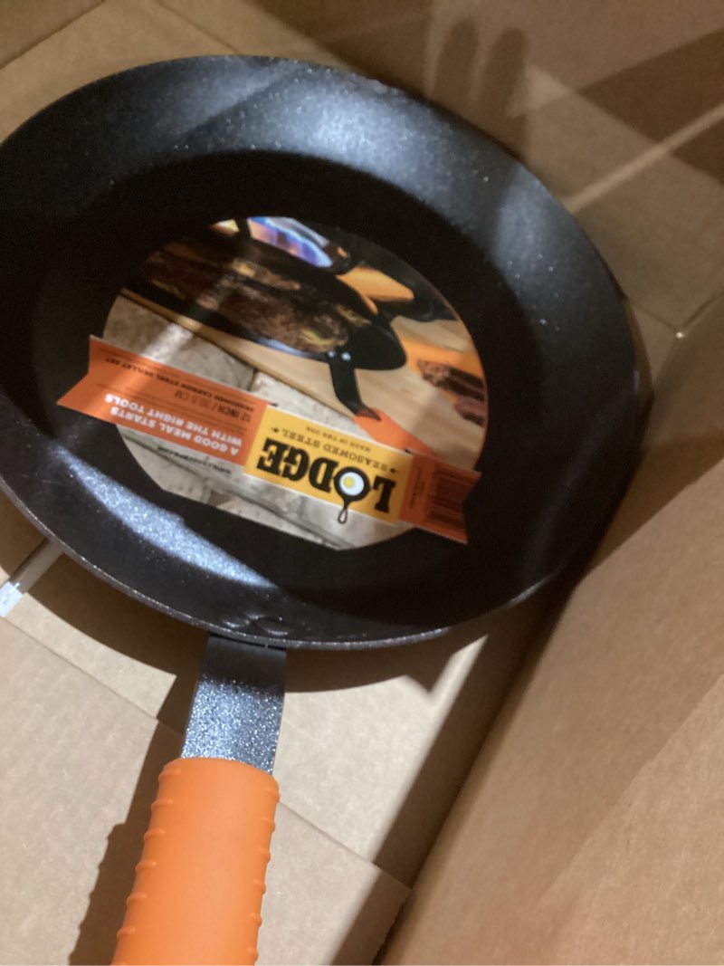 Condition photo showing New/Like New for lodge manufacturing company carbon steel skillet, black/orange, 12-inch 12 inch skillet