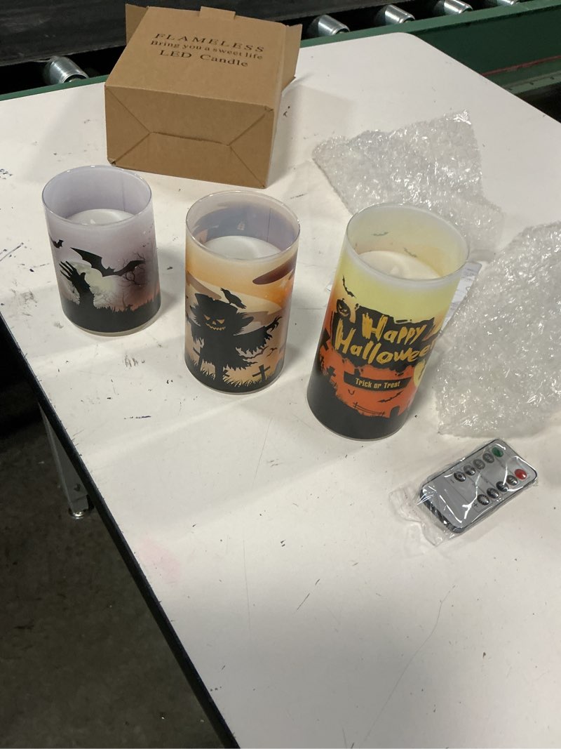 Condition photo showing New/Like New for set of three eldnainte halloween-themed flameless led candles featuring spooky decals like bats, a scarecrow, and a "happy halloween" message