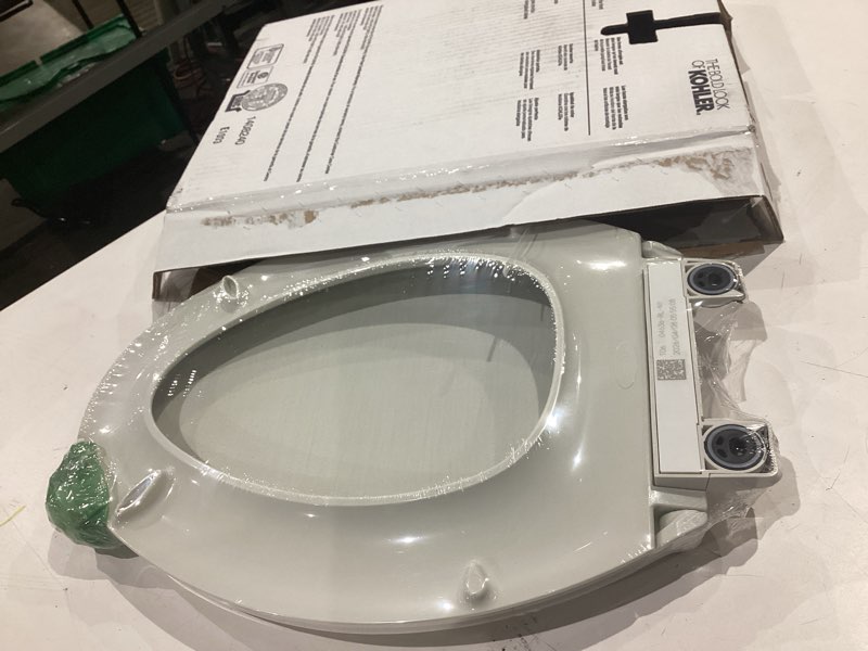 Condition photo showing As Is for kohler 4636-rl-ny cachet readylatch elongated toilet seat, quiet-close lid and seat, countoured seat, grip-tight bumpers and installation hardware, dune