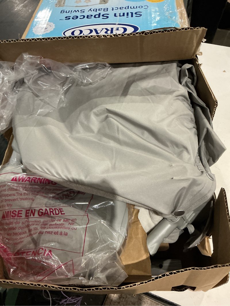 Condition photo showing As Is for graco slim spaces compact baby swing, space saving portable bay swing with height adjustable legs & soft toys, reign