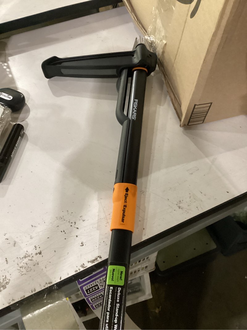 Condition photo showing As Is for fiskars stand-up weed puller tool, 4 serrated stainless steel claws grip roots for permanent removal, reinforced foot platform penetrates tough soil, easy-eject & ergonomic offset handle, 39"